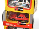 three toy cars are stacked on top of each other on a white surface