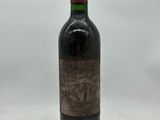 une bouteille de vin rouge posée sur une table blanche
