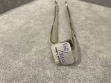 a silver spoon with a tag on it sitting on a table
