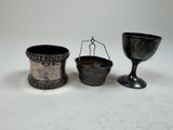 two silver cups and a silver cup on a white surface
