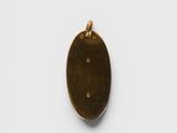 an oval brass pendant with a small hole in the middle