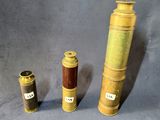 trois types différents de vases en laiton et en bois sur un fond gris