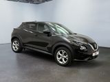 the black nissan c - hr suv is parked in a large room