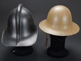 two helmets are sitting next to each other on a black surface