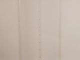 un chevalet en acrylique transparent posé sur un socle, adossé à un mur blanc