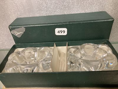 une boîte verte contenant deux plats argentés