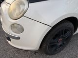 a small white car that has been badly repaired