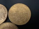 three different types of coins are shown on a black surface