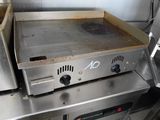 plan de travail en acier inoxydable équipé d'une plaque de cuisson, dans une cuisine professionnelle