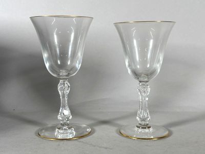 une paire de verres à pied en verre transparent aux bords dorés posés sur une table