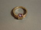 une bague en or sertie d'une pierre rose