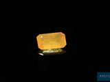 un gros plan d'un quartz jaune posé sur une surface noire