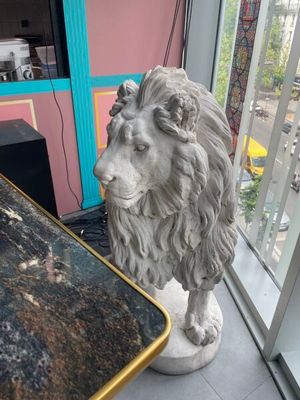 une statue représentant un lion assis à côté d'une table