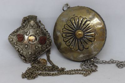 a silver purse with a chain around it on a white surface