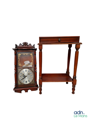 une petite table sur laquelle se trouve une horloge, à côté d'une autre petite table avec une étagère en dessous