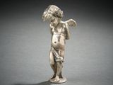 an antique silver figurine of a boy holding a bird