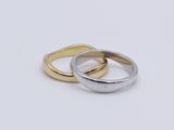 two gold and silver rings sitting on top of each other