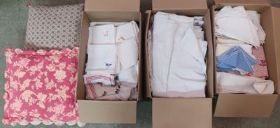 deux cartons de vêtements et un oreiller par terre