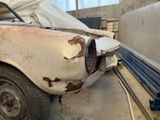 une voiture rouillée qui se trouve dans un garage