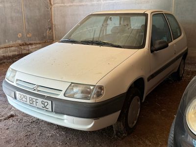 une voiture blanche garée dans un garage à côté d'une voiture noire