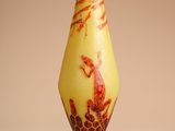 a yellow vase with a bird on it on a stand