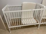 a baby crib with a white mattress in a room