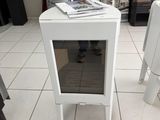 une petite table blanche avec une porte vitrée au milieu de la pièce