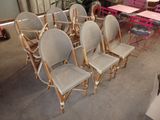 Plusieurs chaises sont alignées dans une pièce où l'on aperçoit, à l'arrière-plan, une table et des chaises.