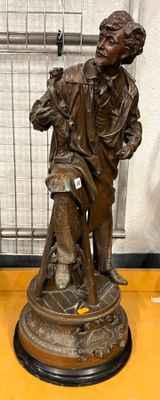 statue en bronze représentant un homme avec un chien, posée sur un socle