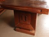 a wooden table with a clock on it in the middle of a room