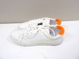 white sneakers with orange laces on them sitting on a white surface