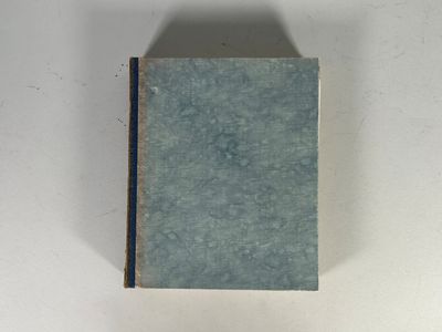 un livre bleu posé sur une table blanche