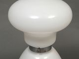 a close up of a white table lamp on a gray surface