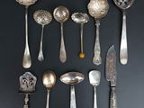 beaucoup de cuillères en argent et de cuillères à soupe sur une table