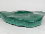a green glass bowl sitting on top of a white table