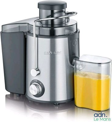 a juicer that is next to a glass of orange juice
