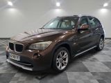 the bmw x1 is parked in the garage on a checkered floor