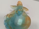 a blue and yellow glass object on a white surface
