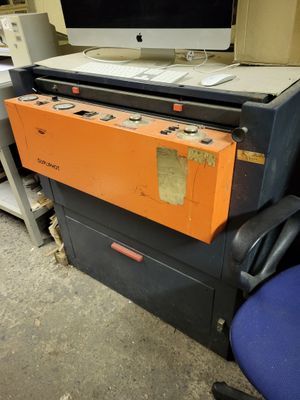 un ordinateur posé sur un bureau, à côté d'une chaise bleue