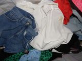 une pile de vêtements posée sur un lit