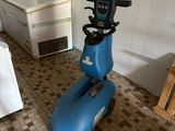 a blue scooter that is sitting in a room
