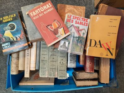 de nombreux livres dans une boîte bleue posée par terre