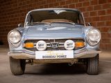 a silver car parked in front of a brick wall