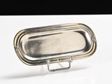 a silver tray with a handle sitting on a table