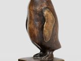 sculpture représentant un manchot sur un socle en marbre, sur fond blanc