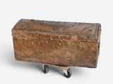 an old suitcase sitting on a dolly on a white surface