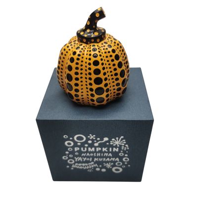 sculpture en céramique représentant une citrouille posée sur un socle à base noire