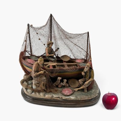 une figurine représentant un bateau avec des personnages à bord et une pomme