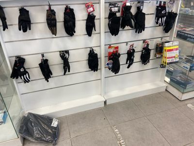 de nombreuses paires de gants accrochées au mur d'un magasin