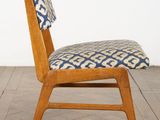 un gros plan d'une chaise en bois dont l'assise est ornée d'un motif bleu et blanc